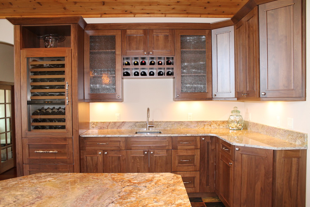 Expansive traditional l-shaped wet bar in Denver with a submerged sink, beaded cabinets, dark wood cabinets, granite worktops, beige splashback and slate flooring.