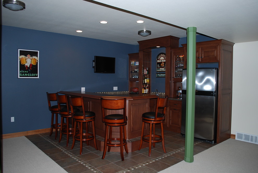 Foto de bar en casa con barra de bar lineal tradicional de tamaño medio con armarios con paneles con relieve, puertas de armario de madera oscura, encimera de madera y suelo marrón