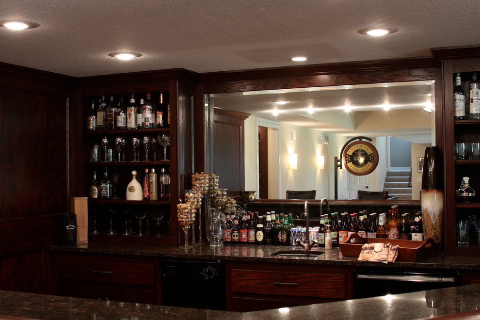 Photo of a large classic u-shaped wet bar in Other with flat-panel cabinets and dark wood cabinets.