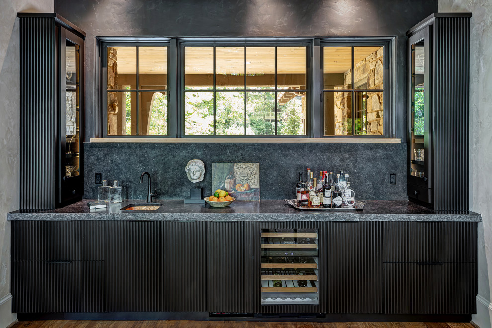 На фото: домашний бар в классическом стиле с врезной мойкой, черными фасадами и фартуком из каменной плиты