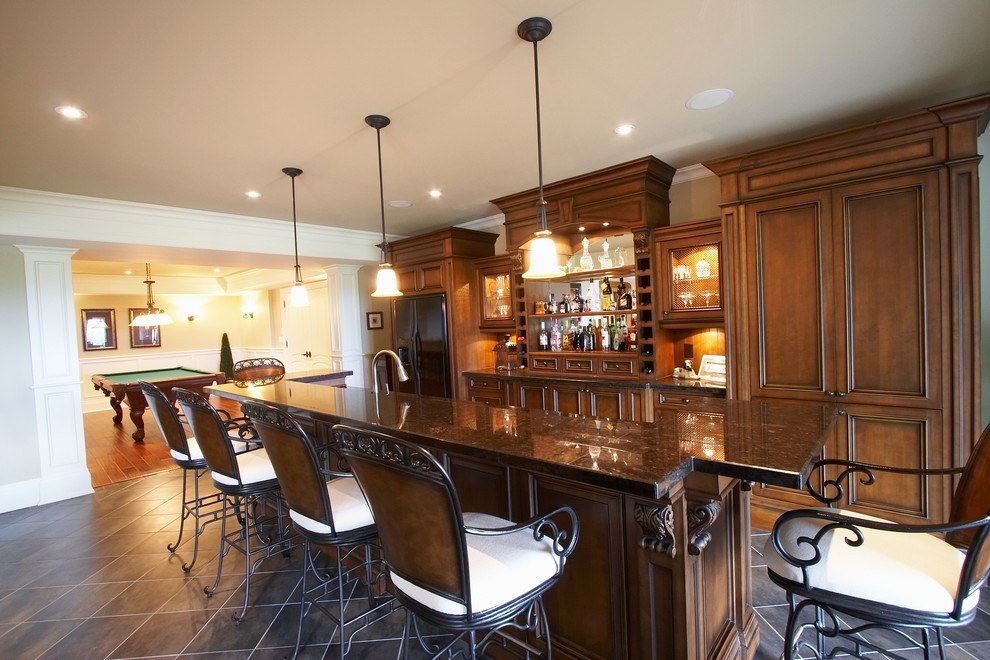 Example of a large classic single-wall seated home bar design in Toronto with recessed-panel cabinets, medium tone wood cabinets and granite countertops