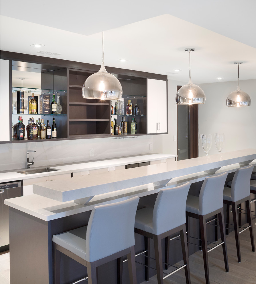 Large modern single-wall breakfast bar in Toronto with flat-panel cabinets, white cabinets and marble worktops.