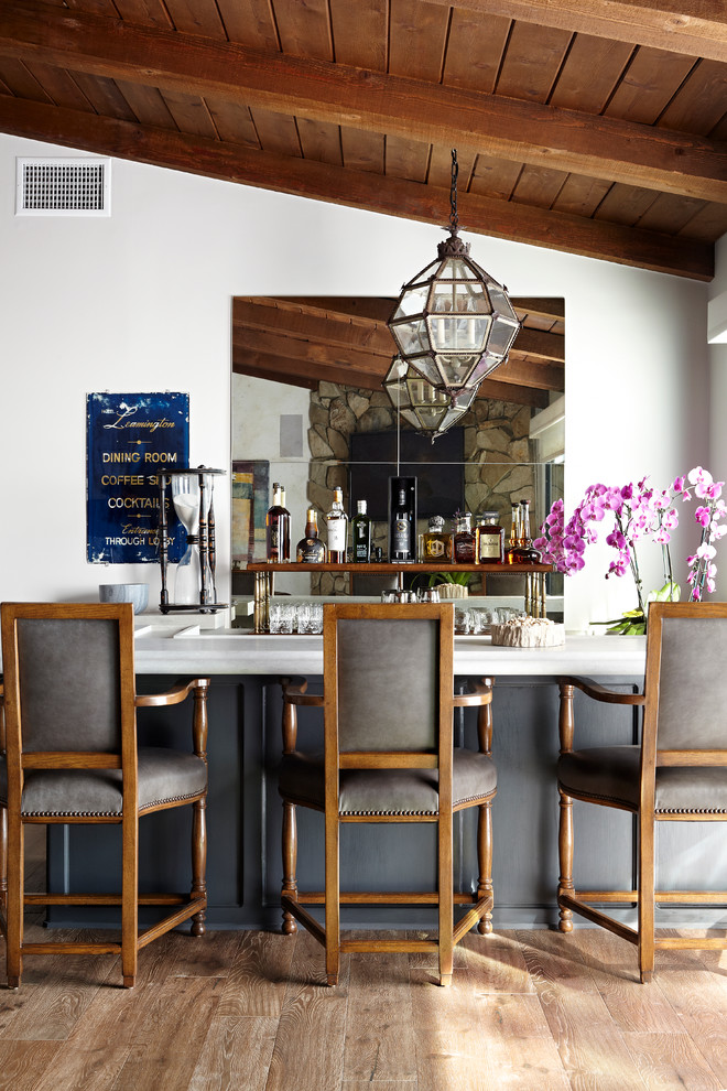 Traditional breakfast bar in Los Angeles with mirror splashback, dark hardwood flooring and white worktops.