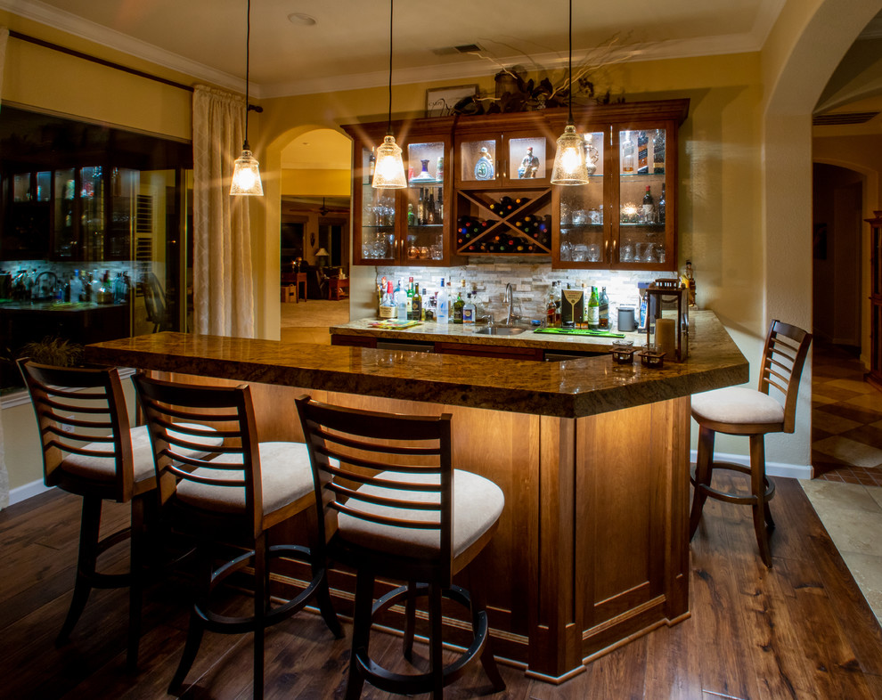 Small transitional single-wall seated home bar photo in Sacramento with an undermount sink, shaker cabinets, brown cabinets, granite countertops and stone tile backsplash
