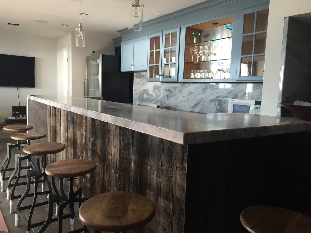 Example of a mountain style l-shaped seated home bar design in Bridgeport with glass-front cabinets, blue cabinets, granite countertops and gray backsplash
