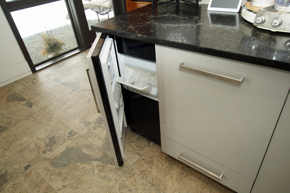 Photo of a large modern l-shaped breakfast bar in Other with a submerged sink, flat-panel cabinets, grey cabinets, engineered stone countertops, grey splashback, stone slab splashback and black worktops.