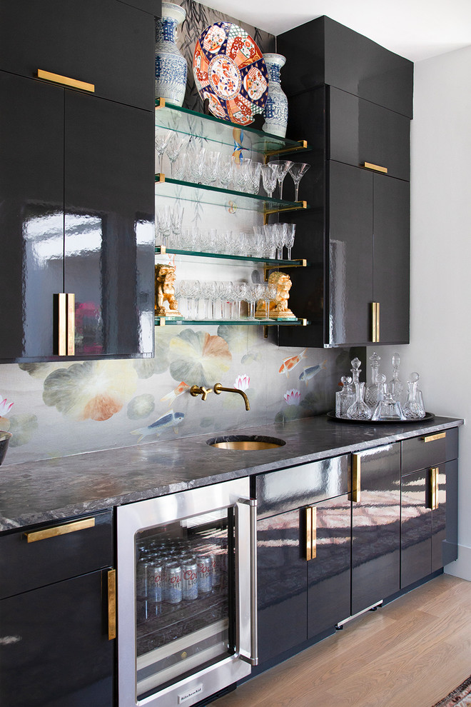 Design ideas for a medium sized contemporary single-wall wet bar in Austin with a submerged sink, flat-panel cabinets, black cabinets, marble worktops, black worktops, medium hardwood flooring, brown floors and a feature wall.