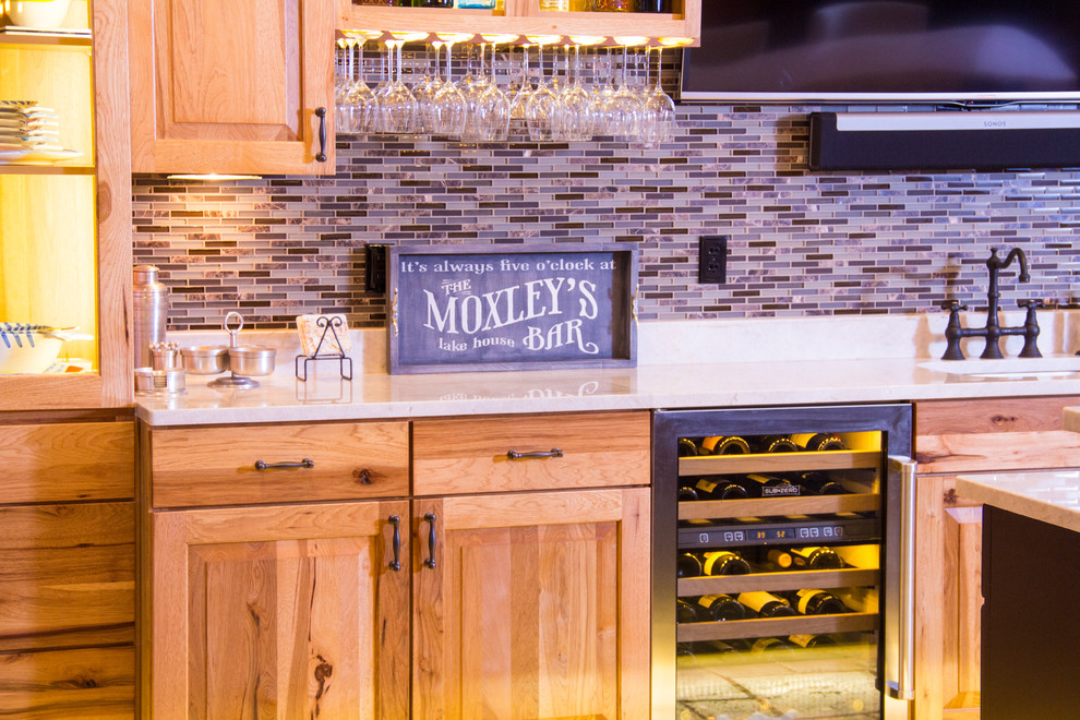 Exemple d'un grand bar de salon chic en bois clair avec un évier encastré, un placard avec porte à panneau surélevé, un plan de travail en quartz modifié, une crédence multicolore et une crédence en carreau briquette.