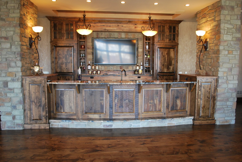 Immagine di un grande angolo bar rustico con lavello sottopiano, ante con bugna sagomata, ante con finitura invecchiata, top in granito e pavimento in legno massello medio