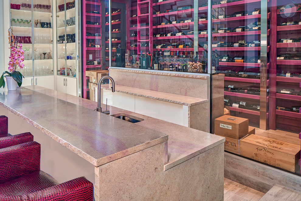 Exemple d'un bar de salon parallèle tendance de taille moyenne avec des tabourets, un plan de travail en calcaire, une crédence beige, un placard sans porte, un évier encastré et un sol en bois brun.