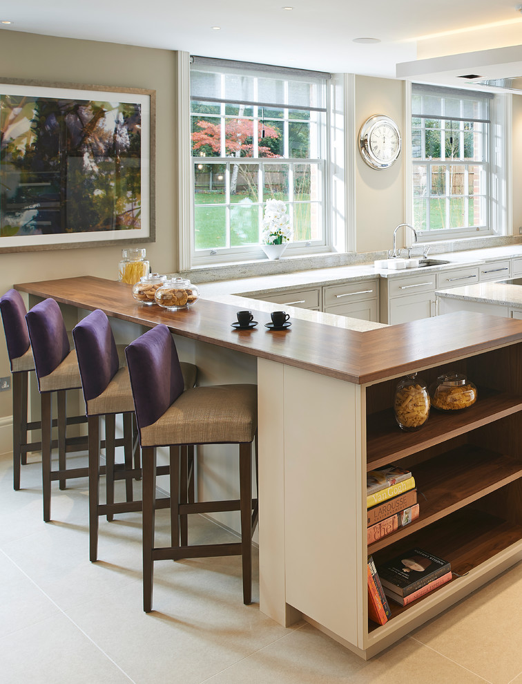 Example of a trendy ceramic tile seated home bar design in Essex with wood countertops