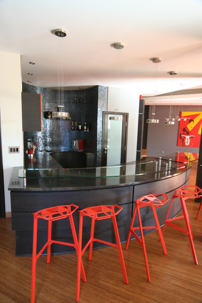 Immagine di un bancone bar minimal di medie dimensioni con ante lisce, ante rosse, top in granito, paraspruzzi con piastrelle di vetro e pavimento in legno massello medio