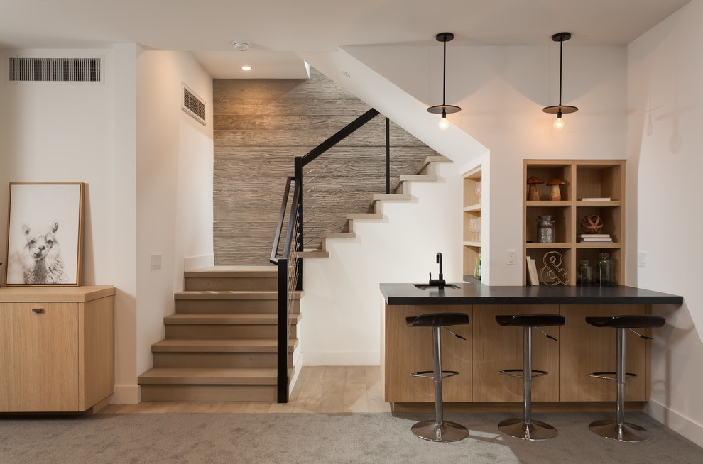 Immagine di un angolo bar design con lavello sottopiano, nessun'anta, ante in legno chiaro e pavimento beige