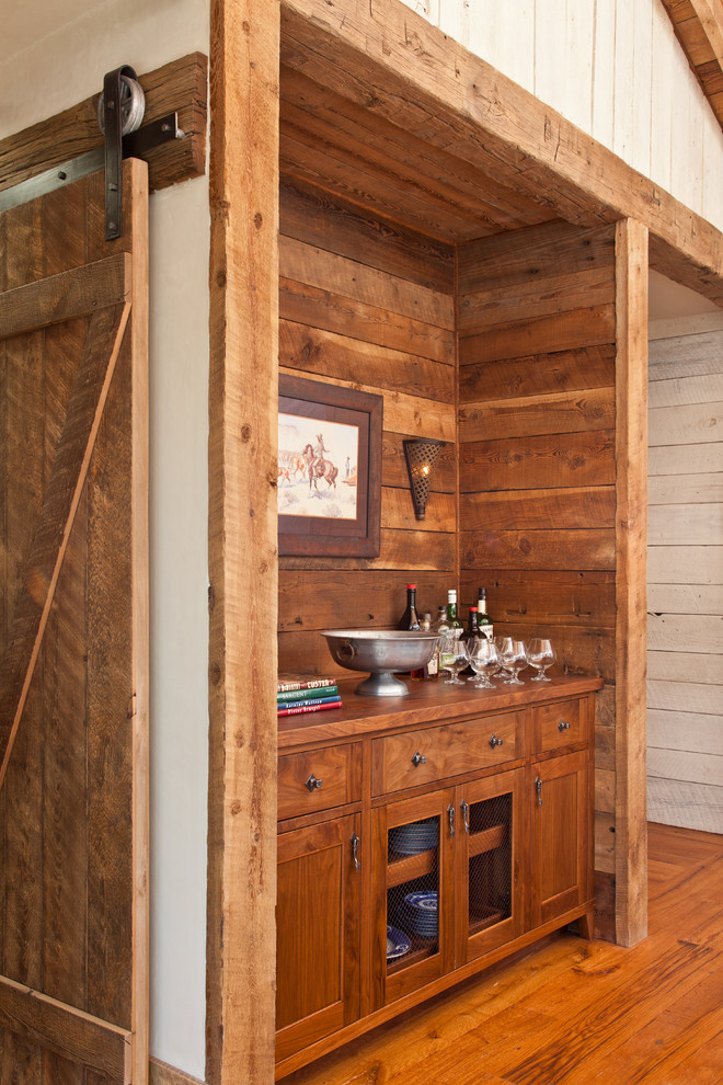 Modelo de bar en casa lineal rural sin pila con puertas de armario de madera oscura, encimera de madera, salpicadero de madera, suelo de madera en tonos medios, encimeras marrones, suelo marrón y armarios estilo shaker