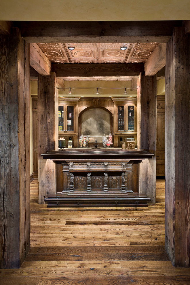 Esempio di un angolo bar rustico con pavimento in legno massello medio e ante in legno bruno