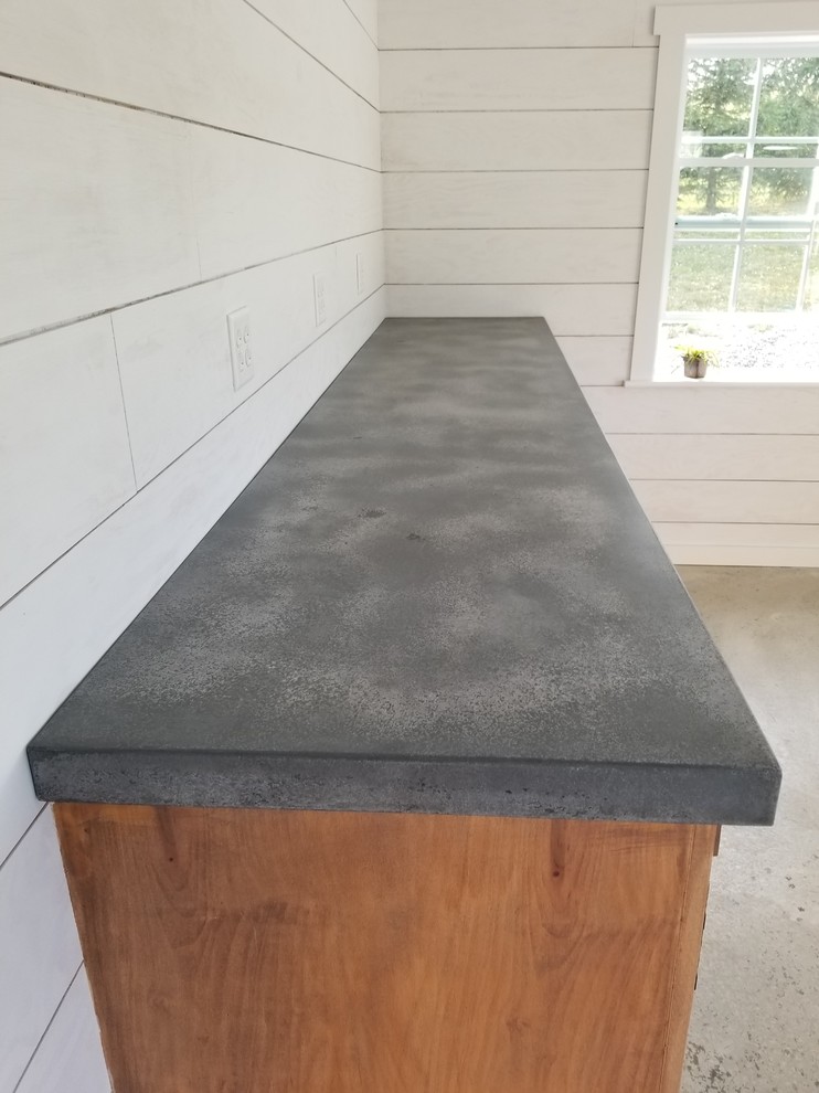 Foto di un angolo bar rustico di medie dimensioni con ante in legno scuro, top in cemento, pavimento in cemento, pavimento grigio e top grigio