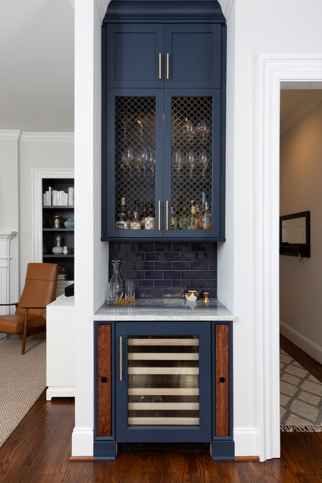 Photo of a small traditional single-wall home bar in Charlotte with shaker cabinets, blue cabinets, blue splashback, metro tiled splashback, dark hardwood flooring, brown floors and white worktops.