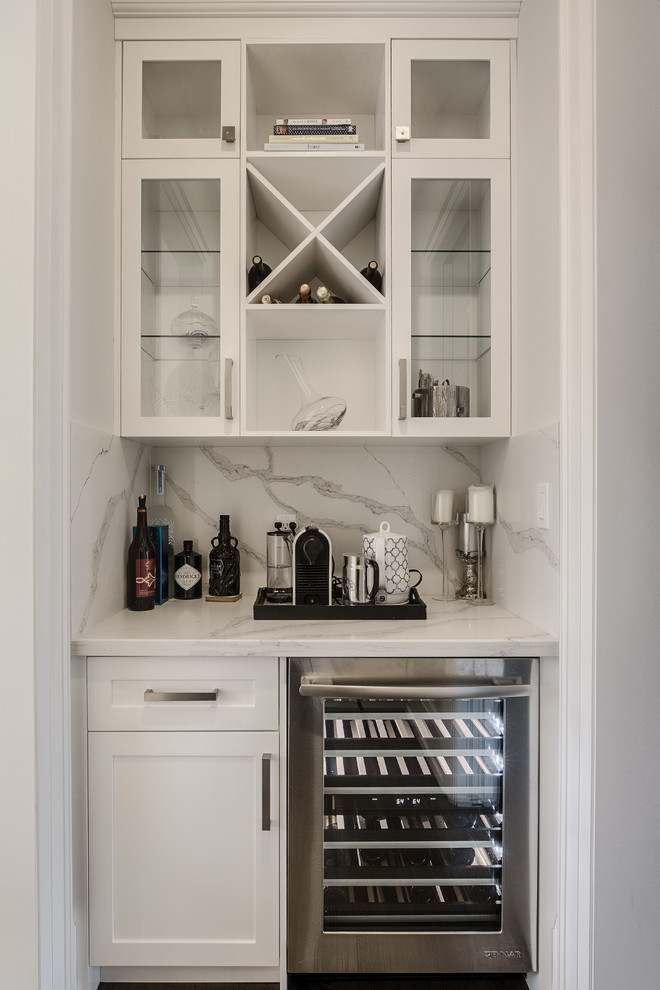 Small contemporary single-wall wet bar in Toronto with no sink, shaker cabinets, white cabinets, marble worktops, white splashback, marble splashback, dark hardwood flooring, brown floors and white worktops.