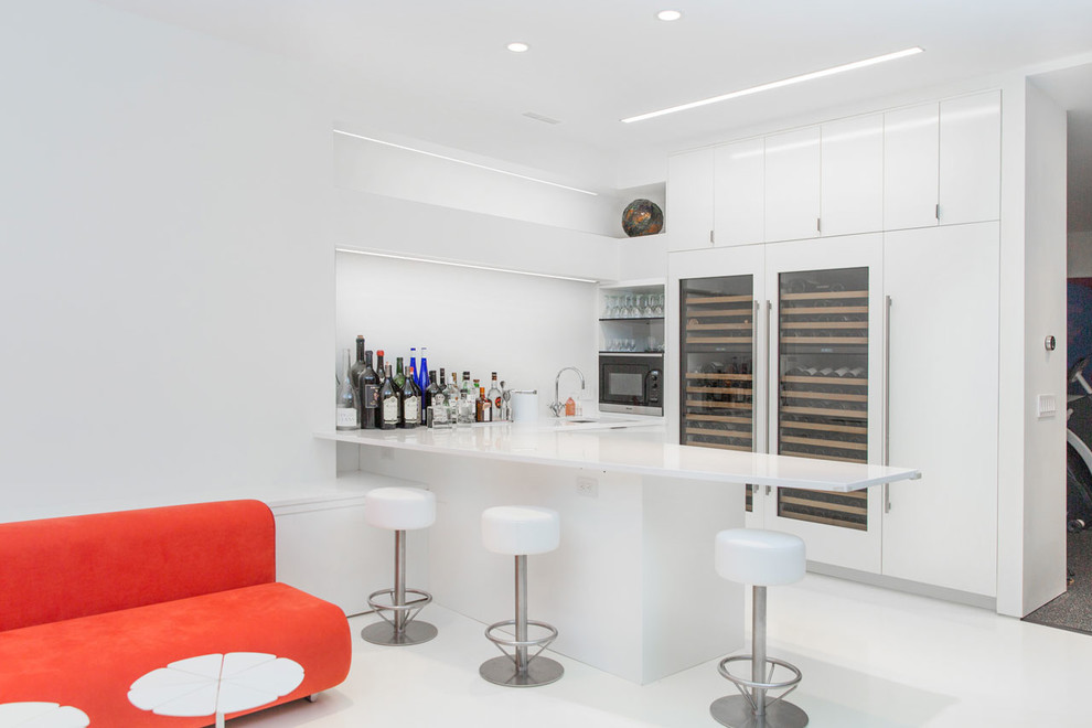 Mittelgroße Moderne Hausbar in L-Form mit flächenbündigen Schrankfronten, weißen Schränken, Quarzwerkstein-Arbeitsplatte, Küchenrückwand in Weiß, weißem Boden und Bartresen in New York