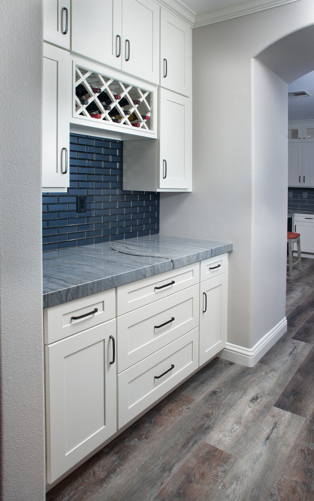Inspiration for a mid-sized transitional galley medium tone wood floor and brown floor wet bar remodel in San Diego with an undermount sink, shaker cabinets, white cabinets, granite countertops, gray backsplash, subway tile backsplash and gray countertops