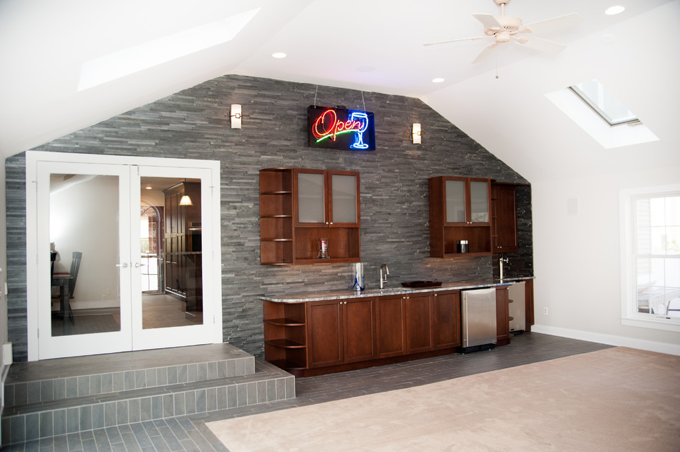 Example of a mid-sized trendy single-wall porcelain tile wet bar design in New York with an undermount sink, shaker cabinets, dark wood cabinets, granite countertops, gray backsplash and stone tile backsplash