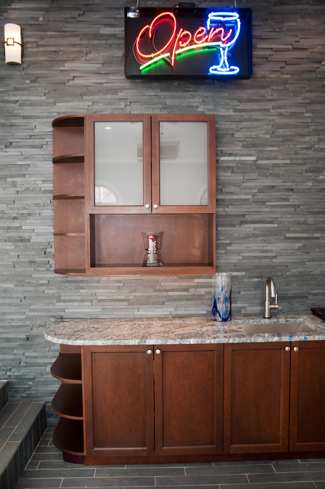 Foto på en mellanstor funkis linjär hemmabar med vask, med en undermonterad diskho, skåp i shakerstil, skåp i mörkt trä, granitbänkskiva, grått stänkskydd, stänkskydd i stenkakel och klinkergolv i porslin