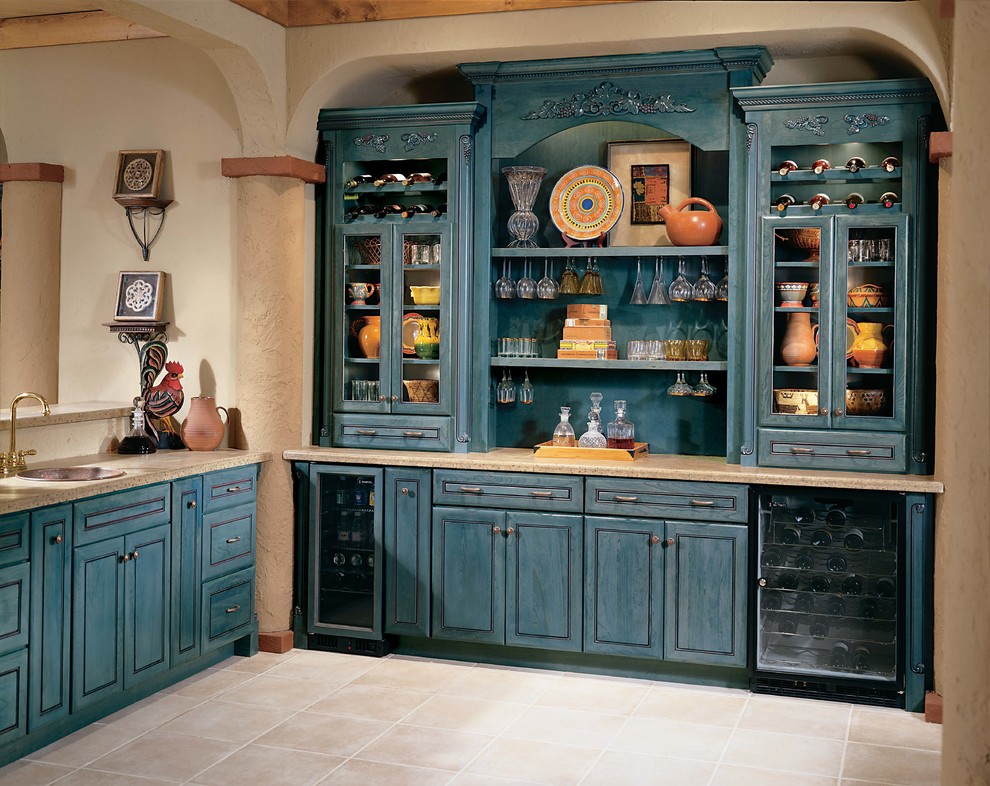 Cette image montre un bar de salon avec évier linéaire rustique de taille moyenne avec un évier posé, un placard avec porte à panneau surélevé, des portes de placard bleues, un sol en travertin et un sol beige.