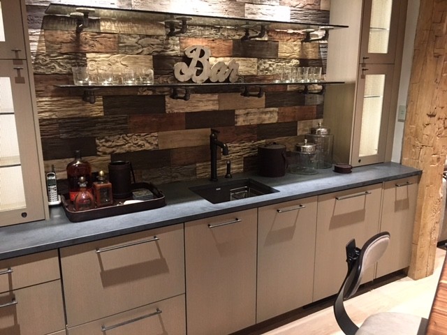 Inspiration for a medium sized traditional single-wall wet bar in Denver with a submerged sink, flat-panel cabinets, beige cabinets, soapstone worktops, brown splashback, wood splashback and beige floors.