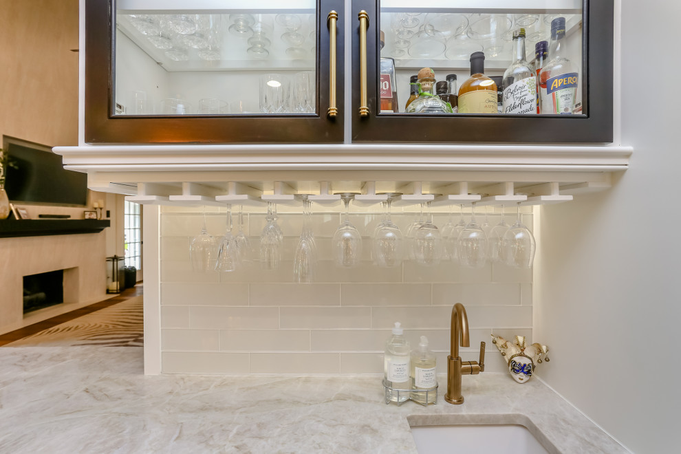 Foto på en mellanstor vintage vita linjär hemmabar med vask, med en undermonterad diskho, luckor med glaspanel, vita skåp, granitbänkskiva, vitt stänkskydd, stänkskydd i glaskakel, mellanmörkt trägolv och brunt golv