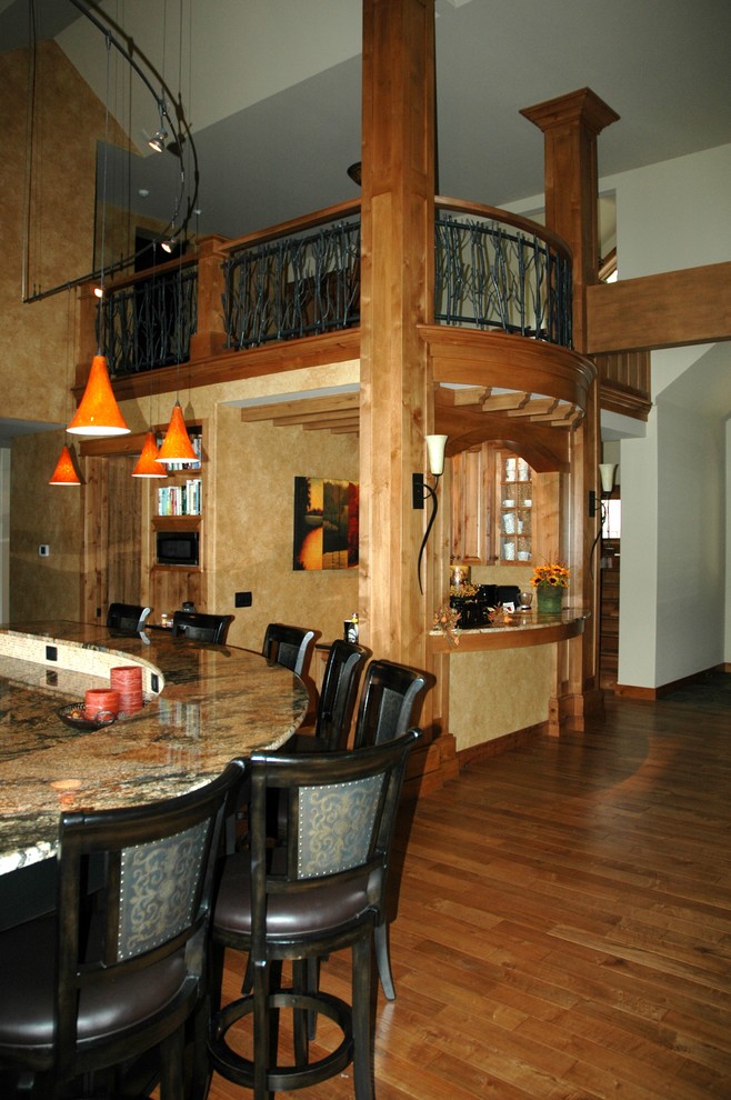 Ispirazione per un bancone bar tradizionale di medie dimensioni con top in granito e pavimento in legno massello medio