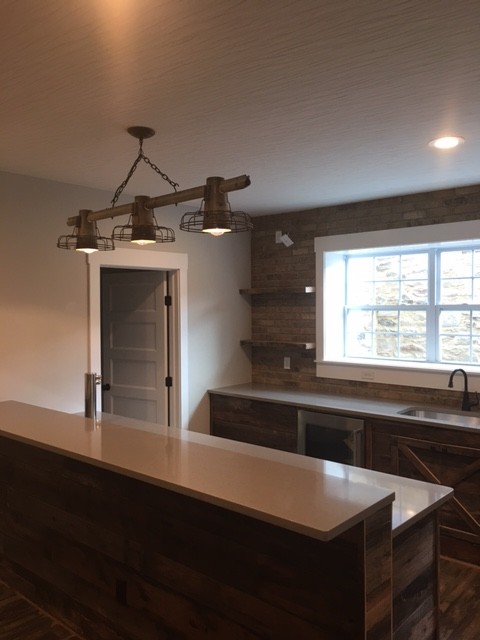 Inspiration for a large classic galley breakfast bar in Columbus with a submerged sink, brown splashback, stone tiled splashback, composite countertops and medium hardwood flooring.