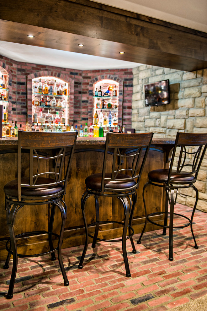 Esempio di un bancone bar stile rurale di medie dimensioni con pavimento in mattoni, pavimento rosso, lavello sottopiano, ante con bugna sagomata, ante in legno bruno, paraspruzzi rosso e top marrone