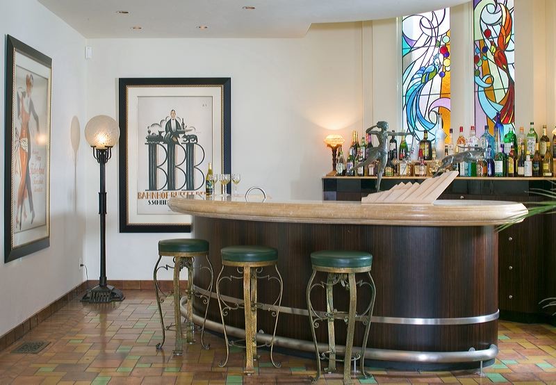 Elegant terra-cotta tile seated home bar photo in Los Angeles with dark wood cabinets
