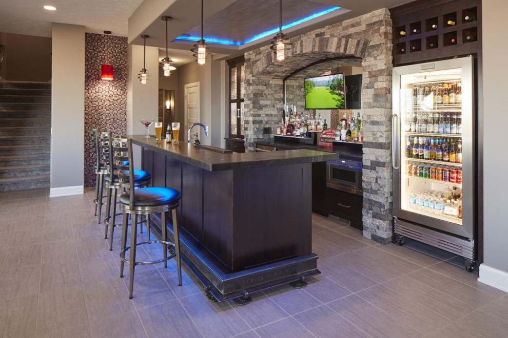 Idee per un ampio bancone bar chic con ante con riquadro incassato, ante in legno bruno, top in granito, pavimento in gres porcellanato, pavimento grigio e top nero