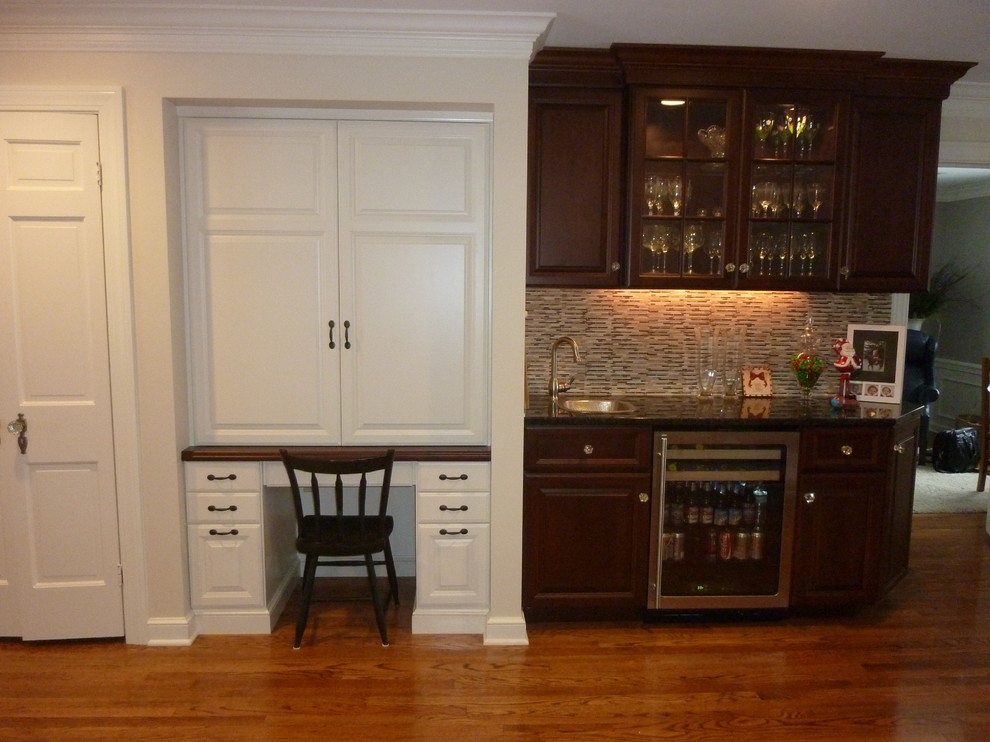 Example of a small classic single-wall dark wood floor wet bar design in Cleveland with a drop-in sink, raised-panel cabinets, dark wood cabinets, quartz countertops, multicolored backsplash and matchstick tile backsplash