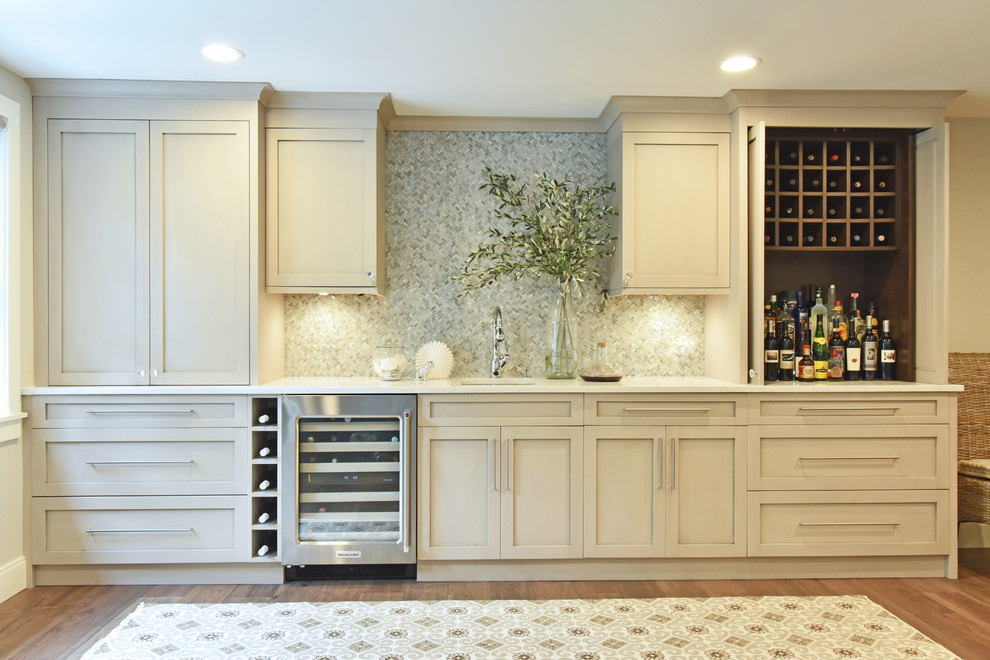 Inspiration for a mid-sized transitional single-wall dark wood floor and brown floor wet bar remodel in Salt Lake City with an undermount sink, recessed-panel cabinets, mosaic tile backsplash, white countertops, gray cabinets, quartz countertops and gray backsplash