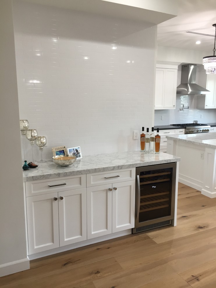 Wet bar - mid-sized traditional single-wall light wood floor and beige floor wet bar idea in San Francisco with shaker cabinets, white cabinets, marble countertops, white backsplash, subway tile backsplash and gray countertops