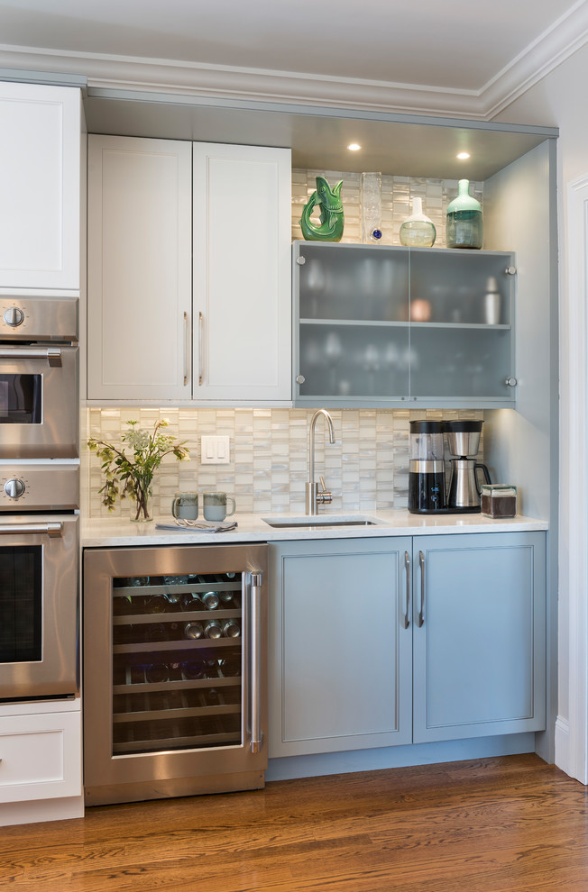 ボストンにあるトランジショナルスタイルのおしゃれなウェット バー (I型、アンダーカウンターシンク、インセット扉のキャビネット、青いキャビネット、白いキッチンパネル、モザイクタイルのキッチンパネル、無垢フローリング、茶色い床、白いキッチンカウンター) の写真