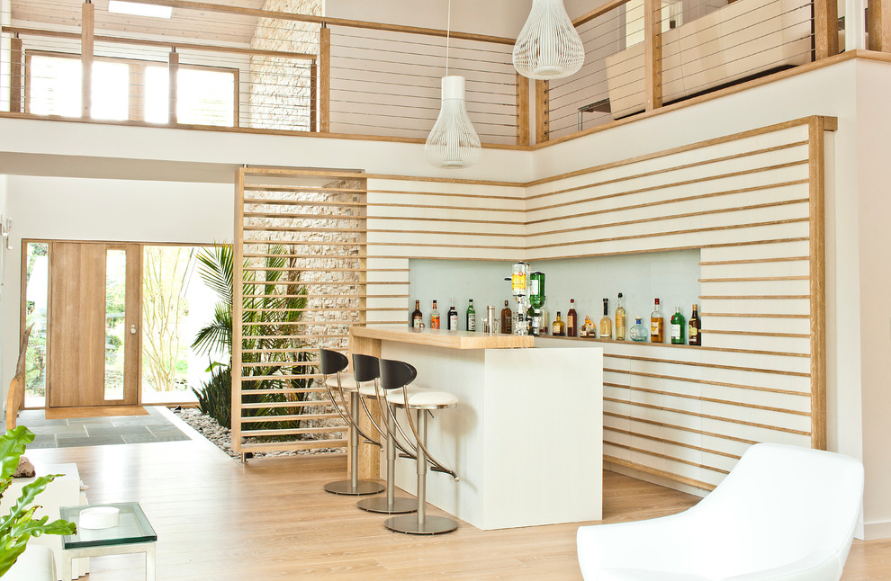 Imagen de bar en casa contemporáneo de tamaño medio con puertas de armario blancas y suelo de madera clara