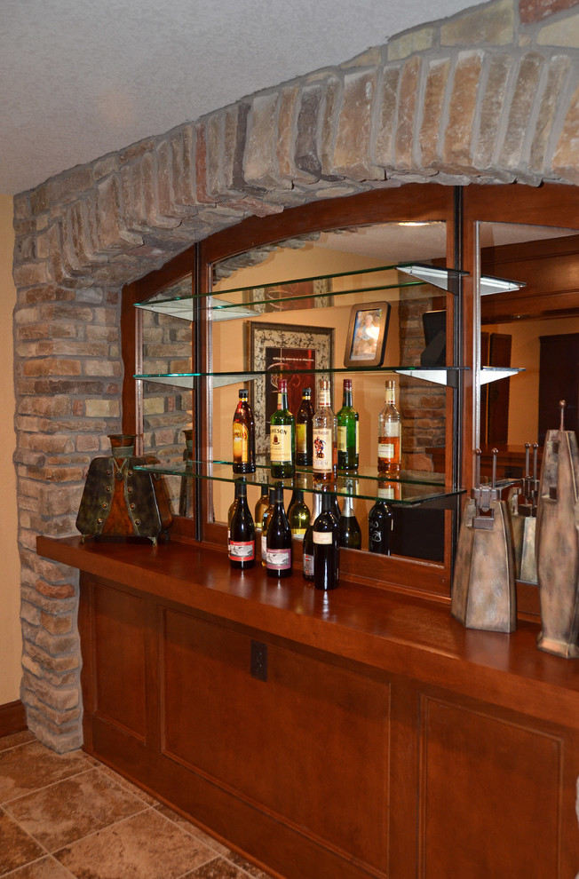 Exemple d'un bar de salon parallèle chic en bois brun de taille moyenne avec des tabourets, un placard à porte plane, un plan de travail en bois, une crédence miroir et un sol en carrelage de céramique.