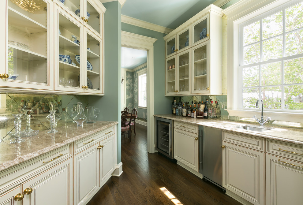 This is an example of a large traditional breakfast bar in Charleston with a submerged sink, raised-panel cabinets, white cabinets, granite worktops, mirror splashback, dark hardwood flooring and brown floors.