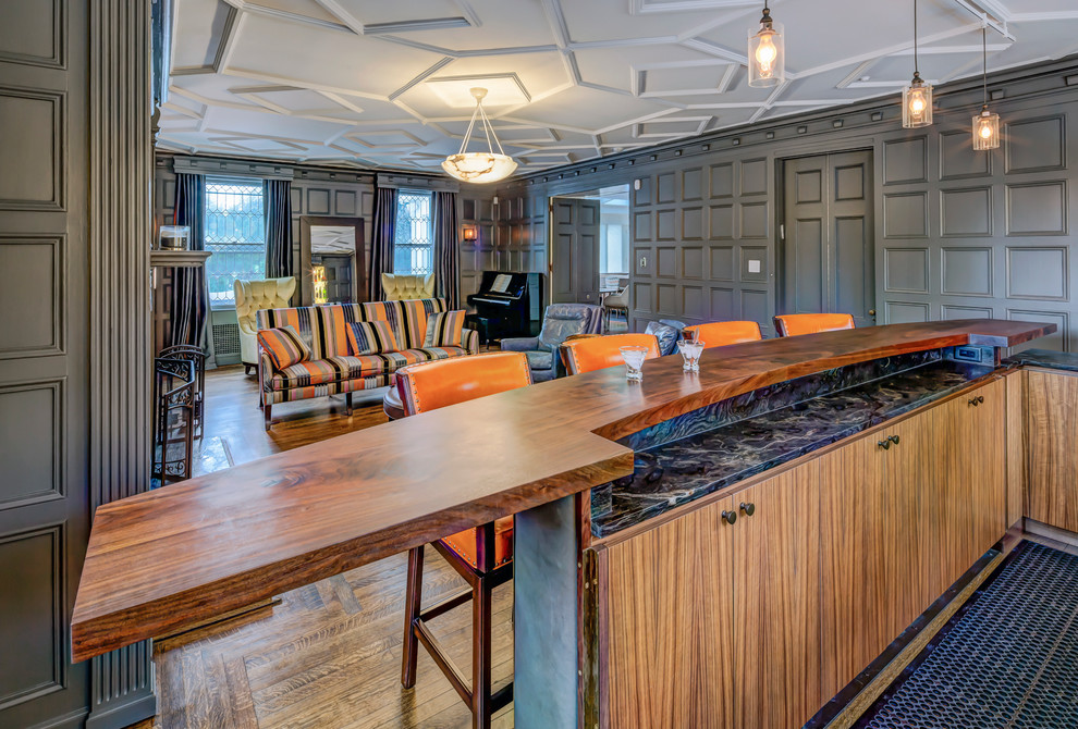 This is an example of a large bohemian galley breakfast bar in New York with a submerged sink, flat-panel cabinets, dark wood cabinets, wood worktops, black splashback, stone slab splashback and dark hardwood flooring.
