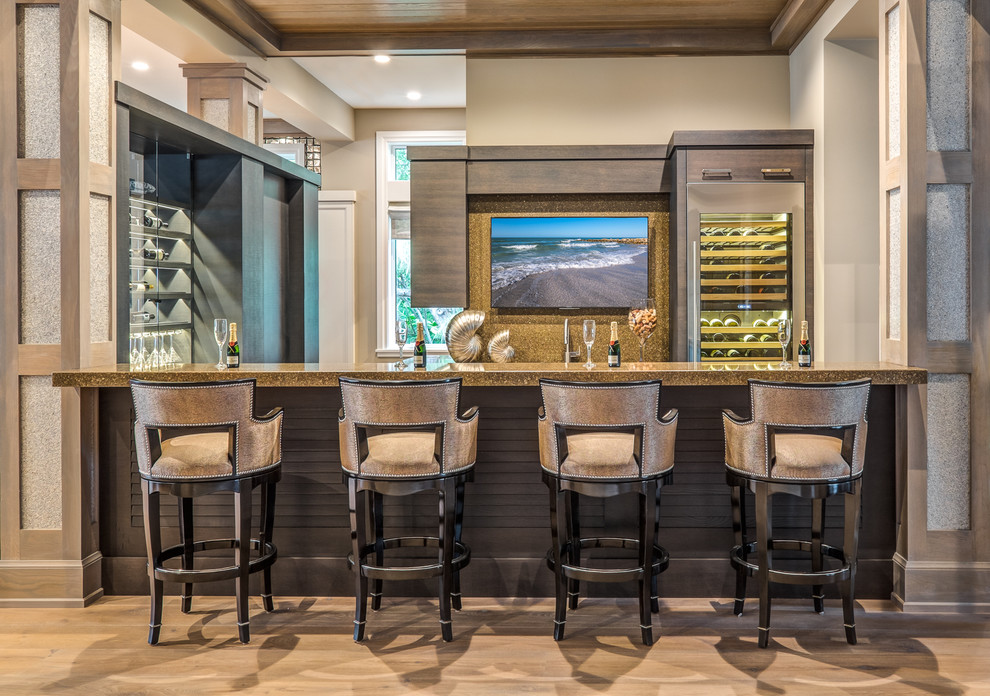 Ejemplo de bar en casa con barra de bar tradicional renovado grande con salpicadero marrón, suelo de madera clara y suelo beige