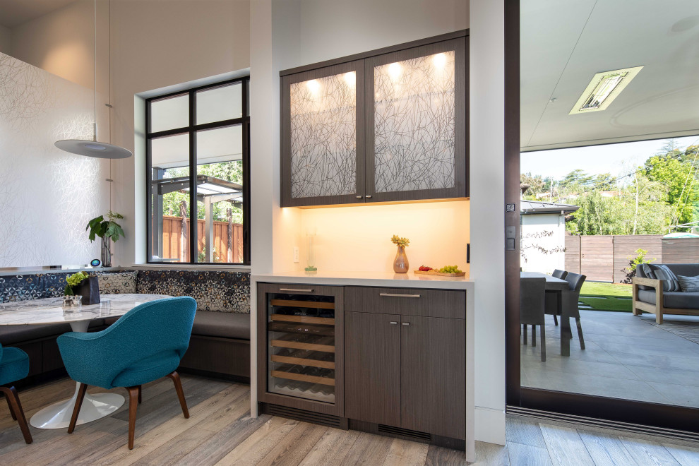 Inspiration for a small contemporary galley breakfast bar in San Francisco with flat-panel cabinets, medium wood cabinets, engineered stone countertops, white splashback, light hardwood flooring, grey floors and grey worktops.