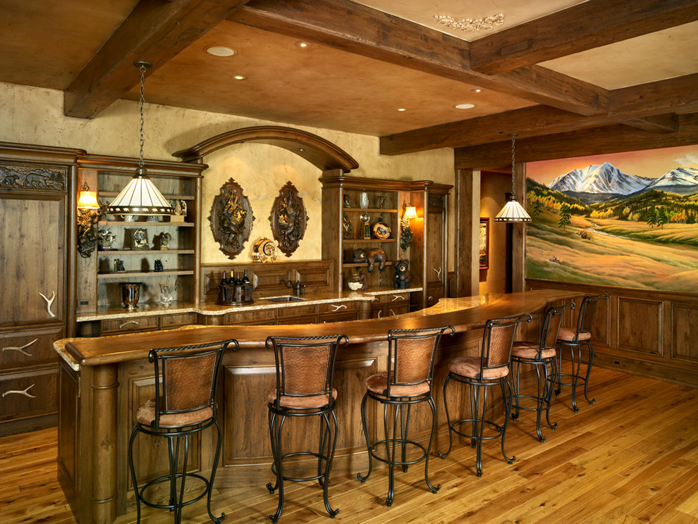 Esempio di un bancone bar stile rurale con nessun'anta, lavello sottopiano, ante in legno scuro e pavimento in legno massello medio