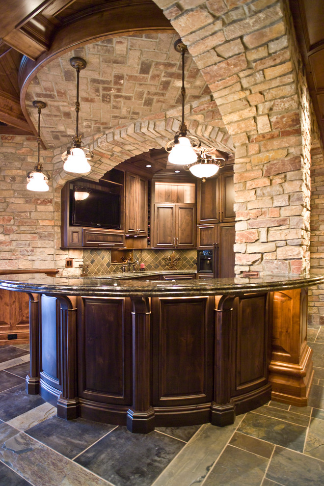 Inspiration for a timeless u-shaped home bar remodel in Other with raised-panel cabinets, dark wood cabinets and green backsplash