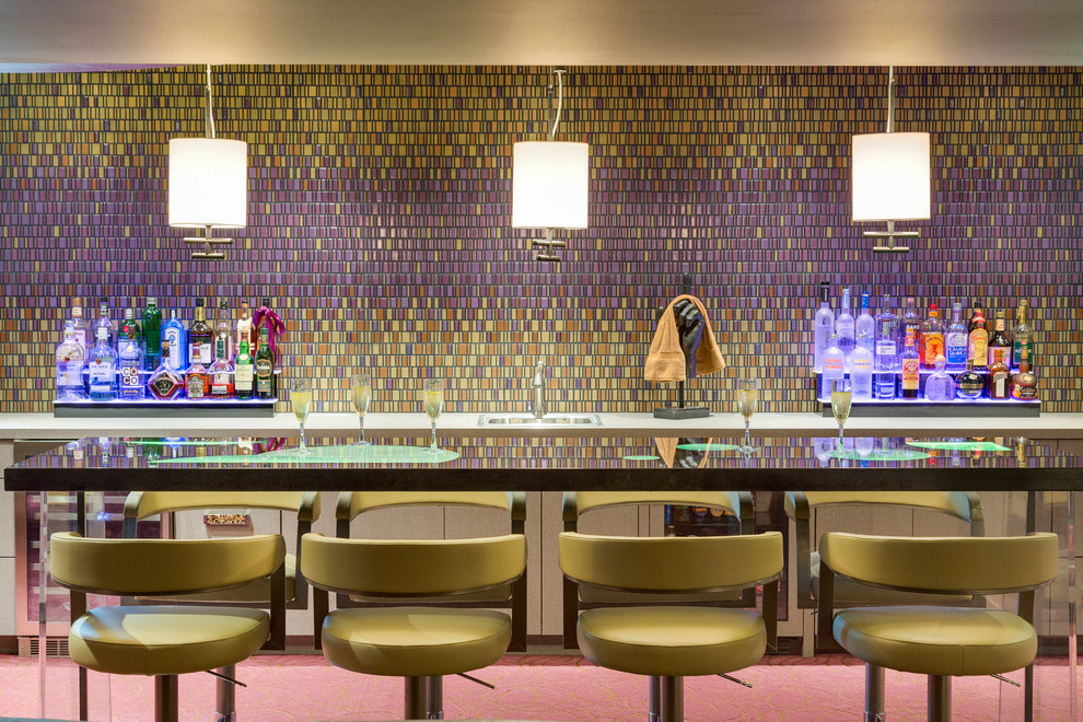 На фото: домашний бар в современном стиле с барной стойкой, разноцветным фартуком и плоскими фасадами с