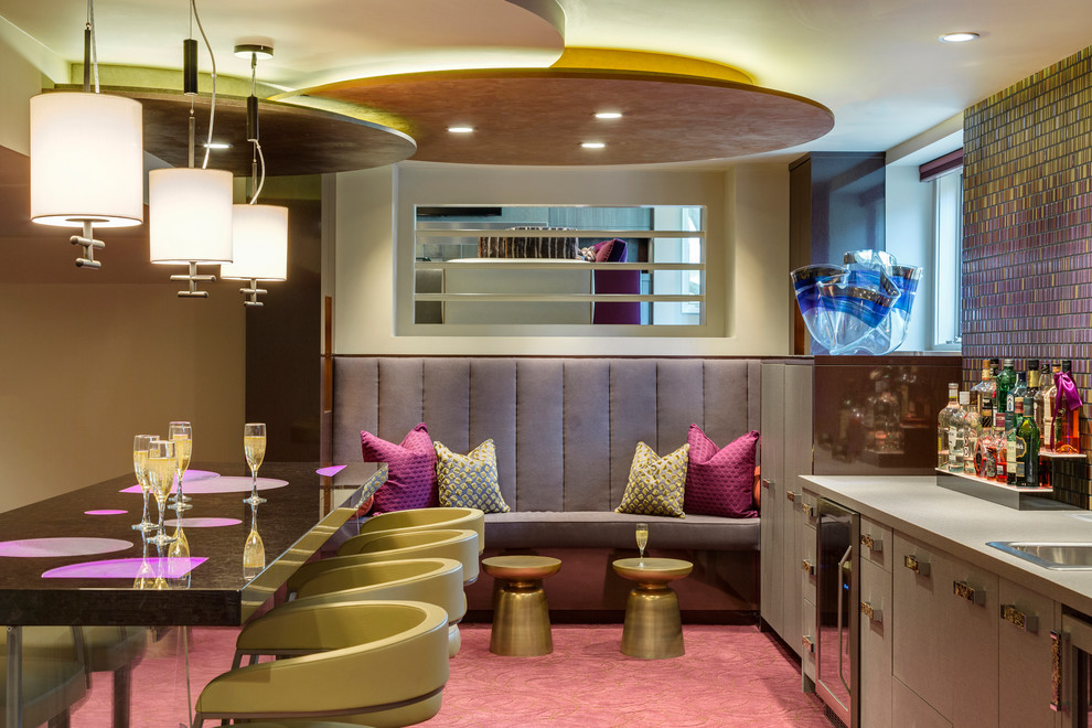 На фото: домашний бар в современном стиле с барной стойкой, разноцветным фартуком, накладной мойкой, плоскими фасадами, серыми фасадами, ковровым покрытием и розовым полом с