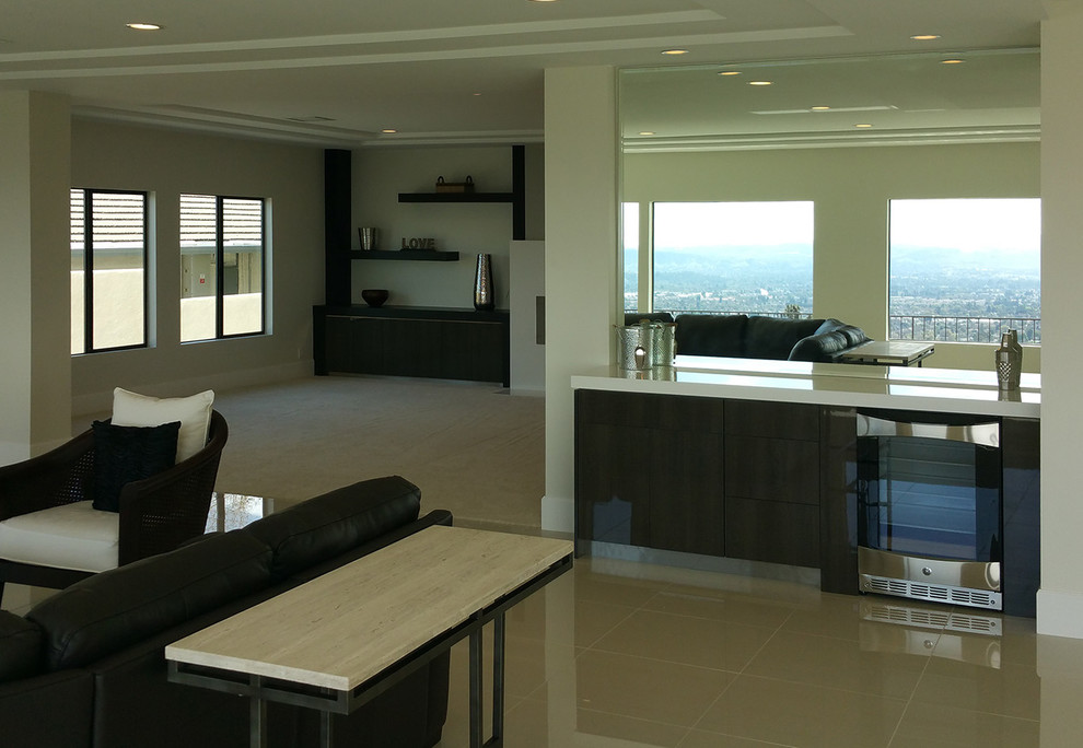 Example of a minimalist single-wall ceramic tile wet bar design in Los Angeles with flat-panel cabinets, dark wood cabinets and solid surface countertops