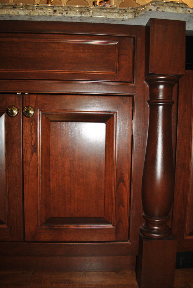 Foto de bar en casa con fregadero lineal tradicional grande con armarios con rebordes decorativos, puertas de armario de madera en tonos medios y encimera de granito